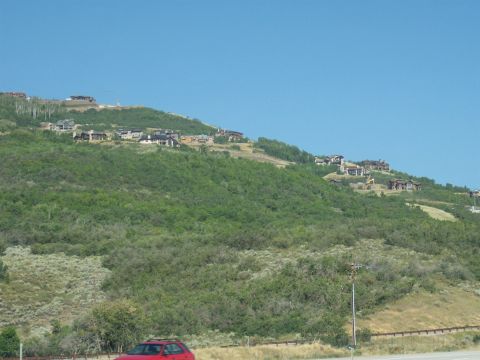 1972 Ford Ranchero - A red car is visible on the side of the road, with houses dotting a distant hillside.