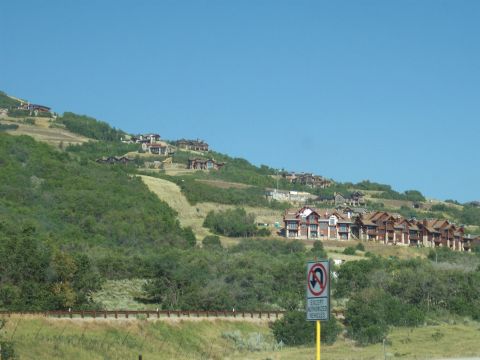 1972 Ford Ranchero - A scenic view of houses built on a hillside under a clear blue sky, with a traffic sign in the foreground.
