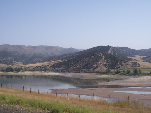 1972 Ford Ranchero - A wide view of a tranquil lake and rolling hills under a bright, cloudless sky, suggesting a peaceful natural setting.