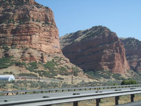 1972 Ford Ranchero - A vast red rock canyon stretches under a clear blue sky, with a highway running through the foreground.