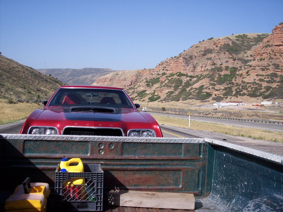 Red 1972 Ford Ranchero front view with black hood scoop, seen from truck bed