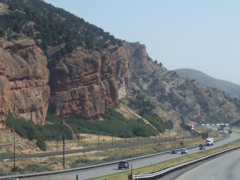 1972 Ford Ranchero - Vehicles travel on a highway alongside a dramatic cliff face.