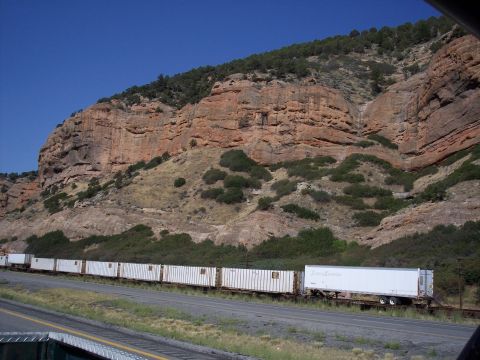 1972 Ford Ranchero - A long train carrying shipping containers travels through a scenic mountain landscape.