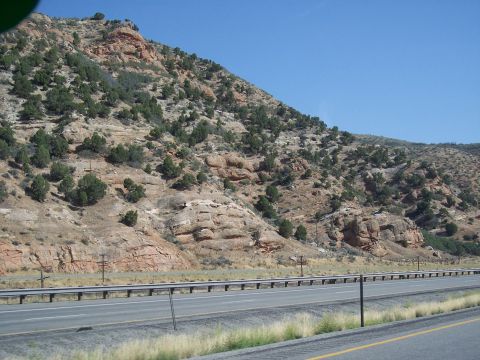 1972 Ford Ranchero - A scenic view of a rocky mountain range alongside a highway, with sparse vegetation dotting the slopes.