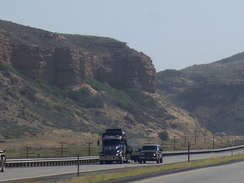 Truck and SUV driving on a highway with mountains in the background