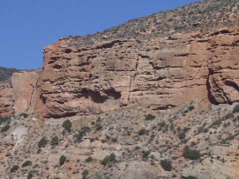 1972 Ford Ranchero - Layered rock formations dominate the landscape, showing geological history under a bright blue sky.