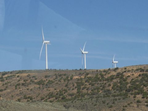 1972 Ford Ranchero - Wind turbines are visible on a distant hillside, generating power against a clear blue sky.