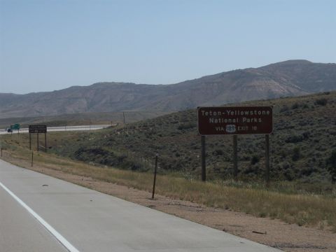 1972 Ford Ranchero - A sign directs travelers to Teton-Yellowstone National Parks from the highway.
