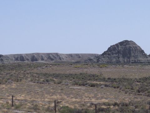 1972 Ford Ranchero - A vast, dry landscape stretches out with distinct geological formations under a bright, cloudless sky.