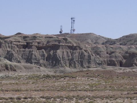 1972 Ford Ranchero - Two communication towers stand atop a desolate, eroded hill, overlooking a dry, scrub-filled plain.
