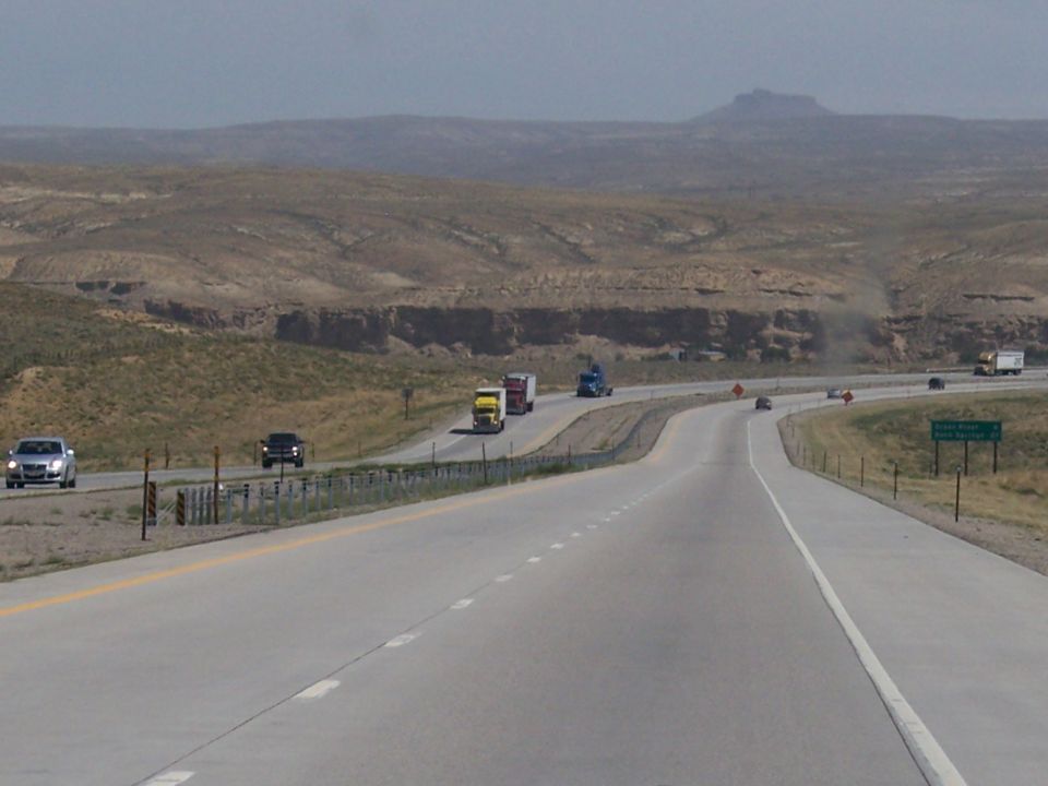 Highway with trucks and cars in a desert landscape