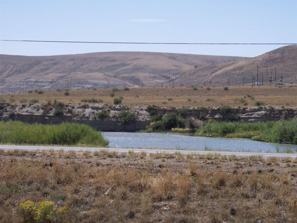 Dry hills and a river under a clear sky