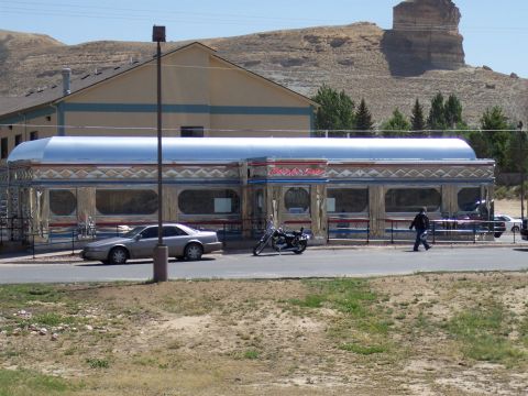 1972 Ford Ranchero - A classic diner sits in front of a rocky hill, with a car and motorcycle parked nearby.