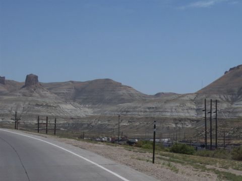 1972 Ford Ranchero - A wide view of a desert landscape with layered hills under a clear blue sky, a road in the foreground.