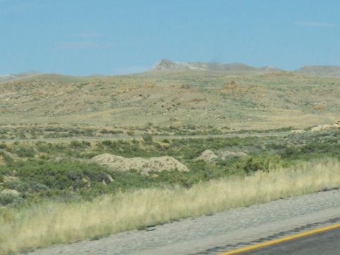 1972 Ford Ranchero - Expansive desert scenery under a clear blue sky, with a road cutting through the terrain.