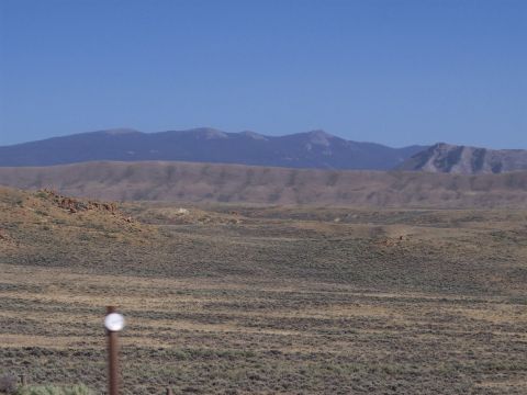 1972 Ford Ranchero - A wide, arid landscape stretches towards hazy mountains under a bright blue sky.