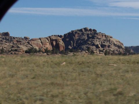 1972 Ford Ranchero - A vast landscape features weathered rock formations and a dry, grassy field under a clear blue sky.