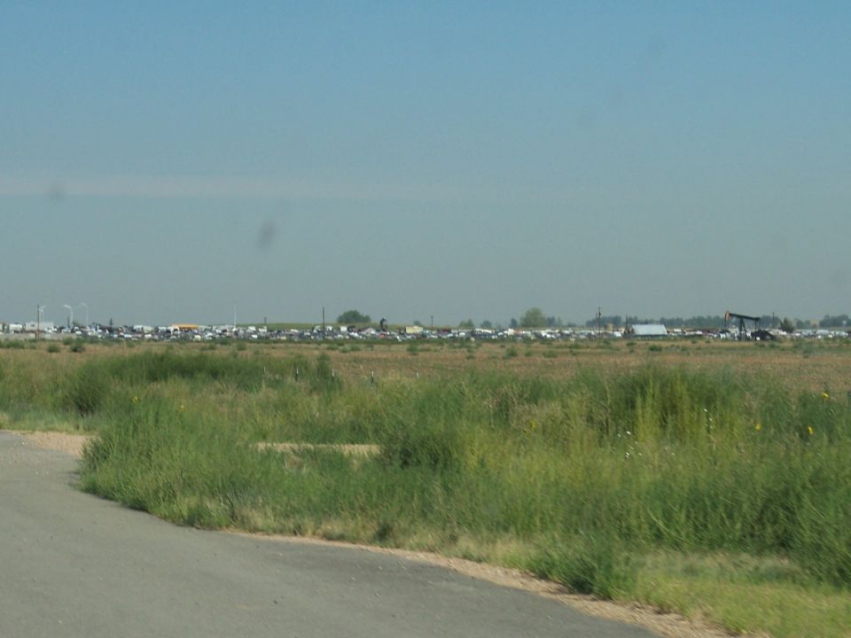 Wide view of a field filled with many vehicles under a clear sky
