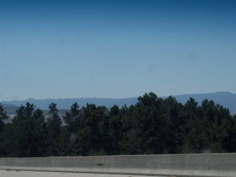 1972 Ford Ranchero - A wide view of a natural landscape trees and distant mountains under a bright blue sky.