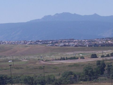 1972 Ford Ranchero - A wide shot captures a suburban area against a backdrop of hazy mountains.