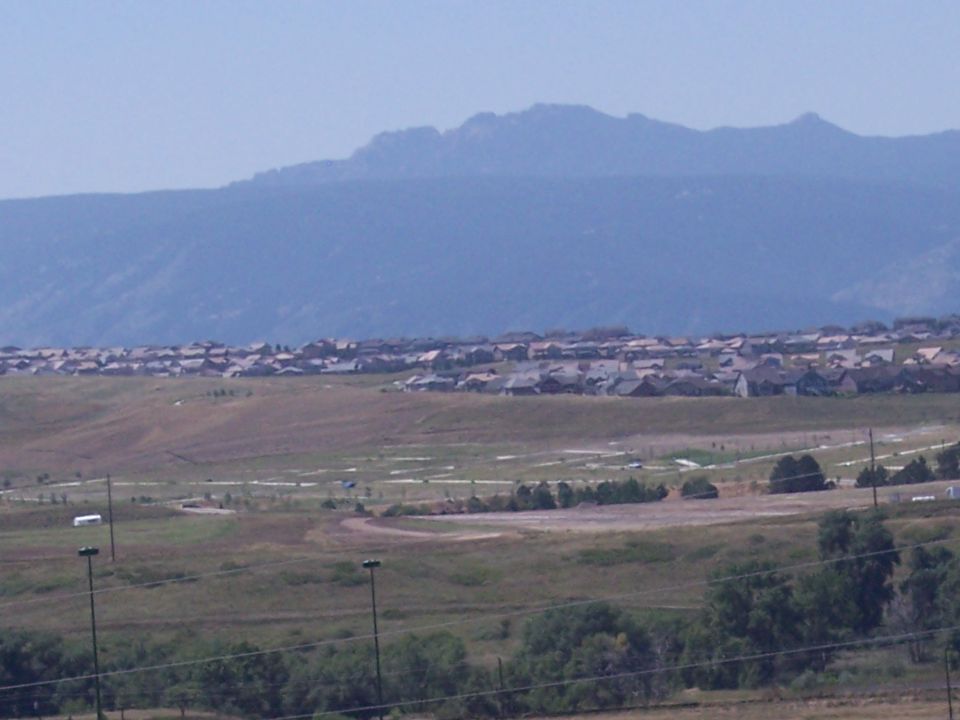 Distant view of a suburban development with houses and mountains in the background