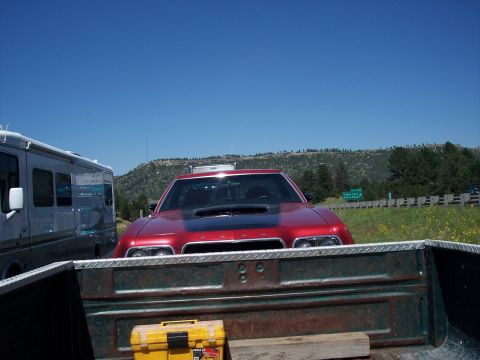1972 Ford Ranchero - A red Dodge Charger is parked in a field next to an RV, seen from the perspective of a pickup truck bed.