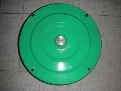 1992 Ford Crown Victoria - A green circular metal part is shown from directly above, resting on a tiled floor.