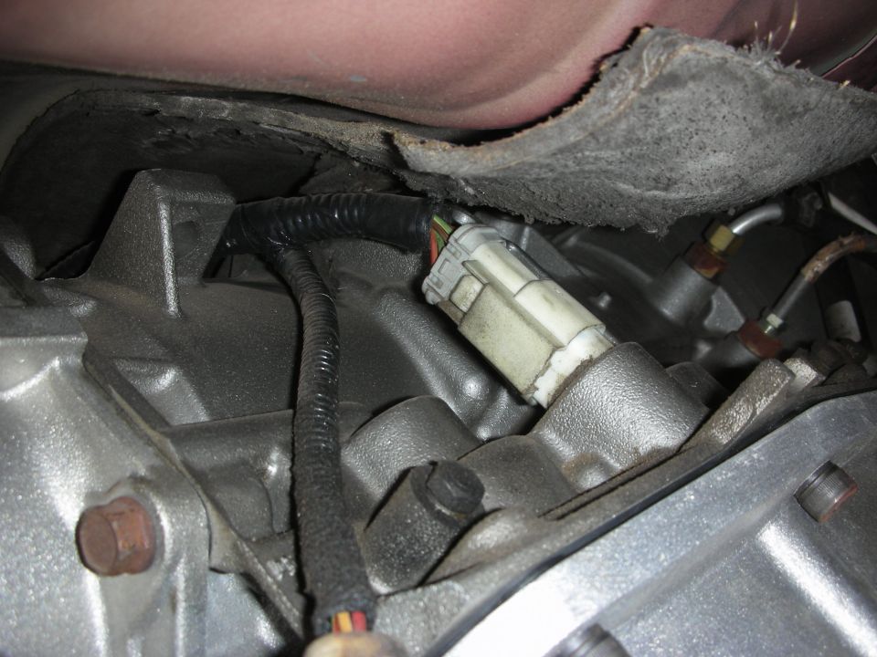 Close-up of a transmission wiring harness connector with black tape and wires