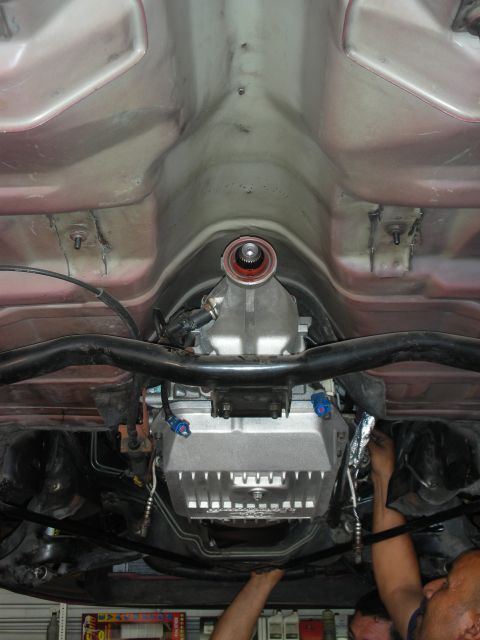 1992 Ford Crown Victoria - The underside of a vehicle shows a transmission with an aftermarket aluminum pan and associated components.