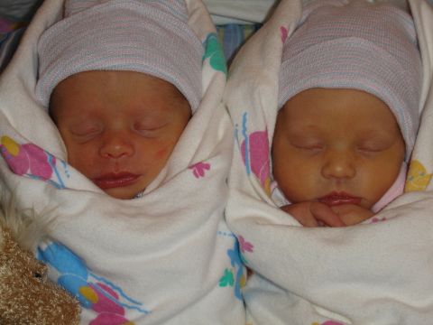 1994 Ford Bronco - Two newborns are peacefully sleeping, swaddled in blankets and wearing hospital caps.