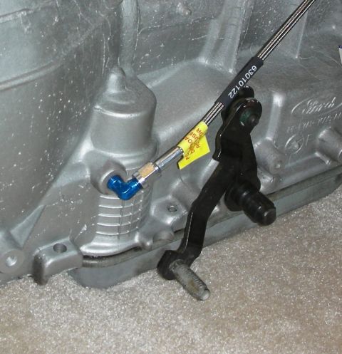 1992 Ford Crown Victoria - A yellow tag with text is attached to a cable on a Ford transmission housing.