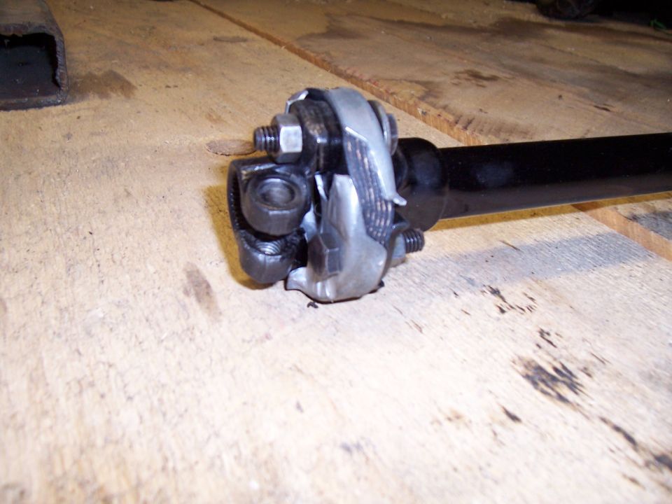 Driveshaft universal joint with U-bolts and nuts on a wooden surface