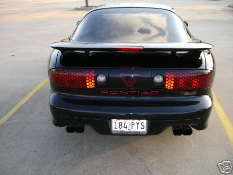 2002 Pontiac Trans Am - The rear of a black Pontiac Trans Am is shown, its distinctive honeycomb taillights and a spoiler.
