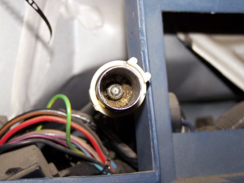 1986 Ford Bronco - A close-up view of a vehicle's cigarette lighter socket, showing internal dust and surrounding wiring.