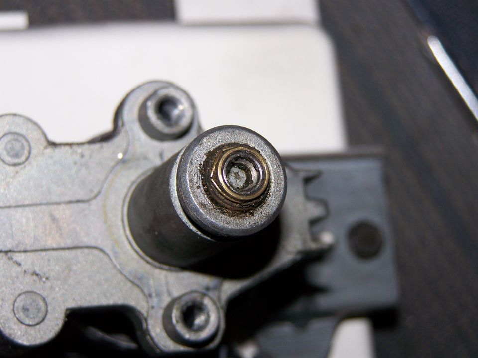 Close-up of a speedometer drive gear assembly with a spring visible
