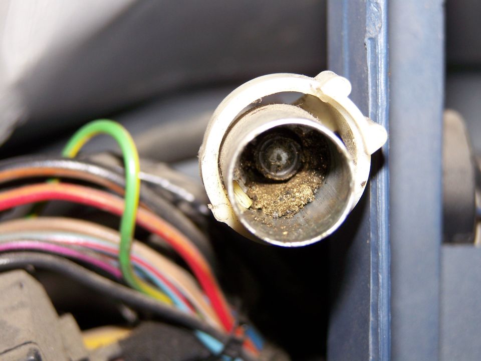 Close-up of a dusty electrical connector with multiple colored wires and a SuperMotors.net watermark