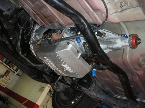 1992 Ford Crown Victoria - The underside of a vehicle reveals its transmission, exhaust pipes, and drive shaft, suggesting aftermarket upgrades.