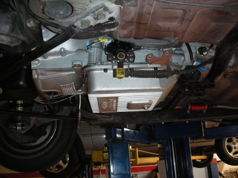 1992 Ford Crown Victoria - Underside view of a vehicle's transmission pan, showing mechanical components and a shifter cable.