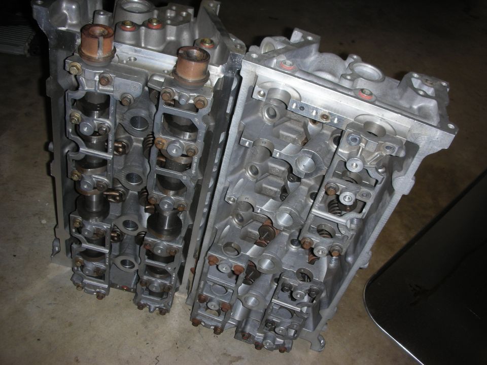 Two aluminum engine cylinder heads with camshafts and valves visible