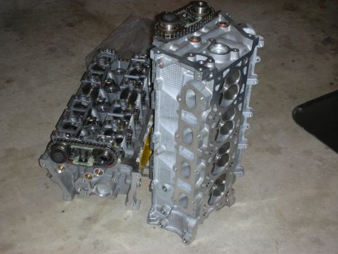 1998 Ford Crown Victoria - Two engine cylinder heads are shown, one a timing chain and sprockets, indicating internal engine components.