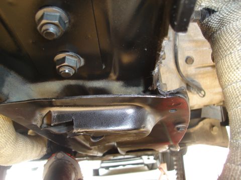 1995 Mazda MX-6 - Close-up of the undercarriage shows mechanical components and exhaust system with heat shielding.