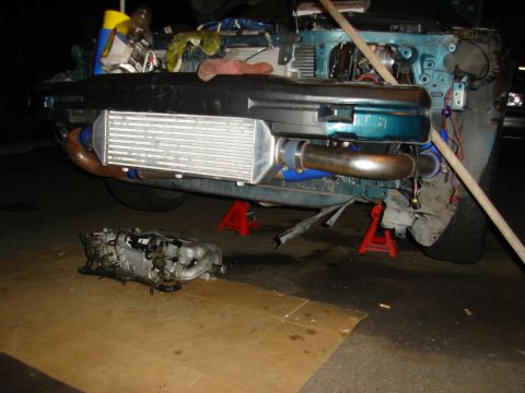 1995 Mazda MX-6 - Car's front end disassembled, showing an aftermarket intercooler and engine parts laid out on the ground.