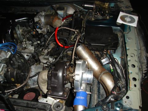 1995 Mazda MX-6 - The engine bay shows a custom turbocharger setup with various hoses and wiring.