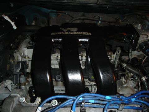 1995 Mazda MX-6 - Close-up of an engine bay, focusing on the intake manifold and spark plug wires.