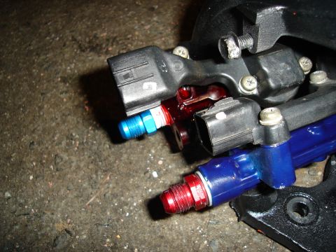 1995 Mazda MX-6 - Fuel rail and injectors with electrical connectors, likely from a performance vehicle modification project.