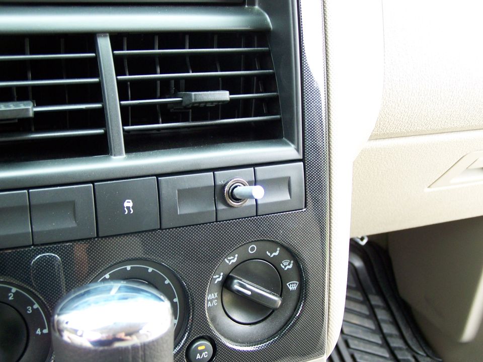 Dashboard interior with air vents, climate controls, and a toggle switch