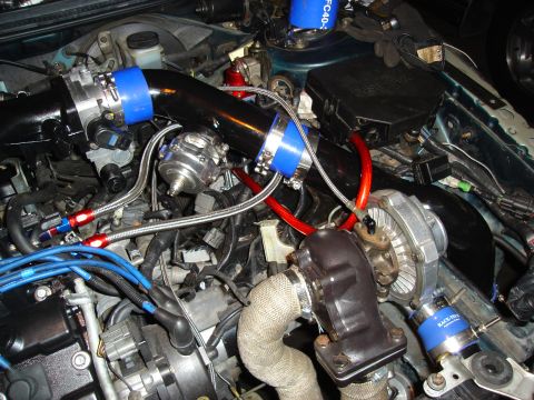 1995 Mazda MX-6 - Custom turbo setup with braided lines and blue couplers is installed in the engine bay.