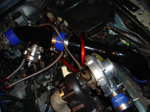1995 Mazda MX-6 - Custom turbocharger setup with black piping and blue couplers, a blow-off valve and a prominent fuse box.