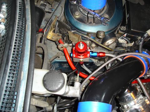 1995 Mazda MX-6 - Close-up of engine bay components including a fuel pressure regulator and intake piping.