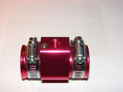 1993 Mazda MX-3 - A close-up view of a red aluminum water temperature fitting with hose clamps.